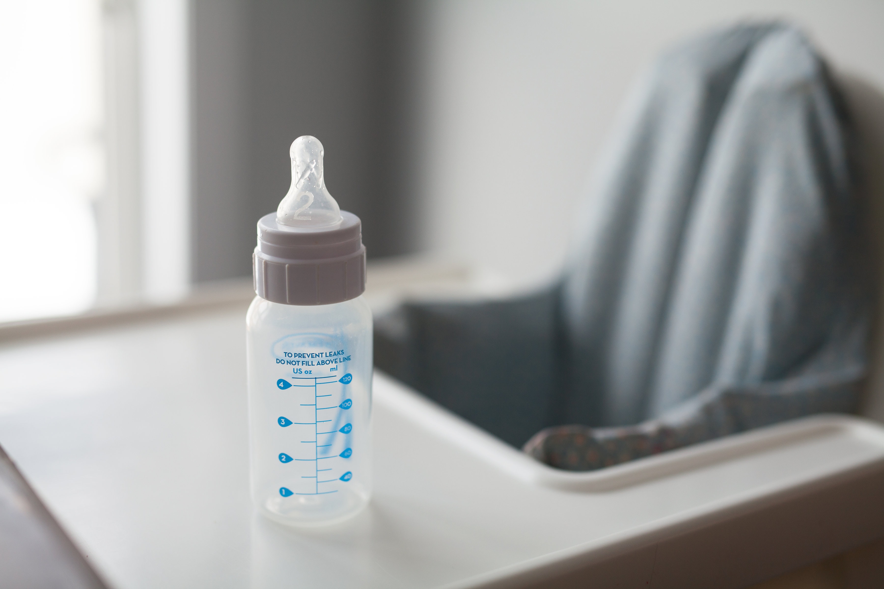 baby bottle on a high chair representing an alternative to breastfeeding