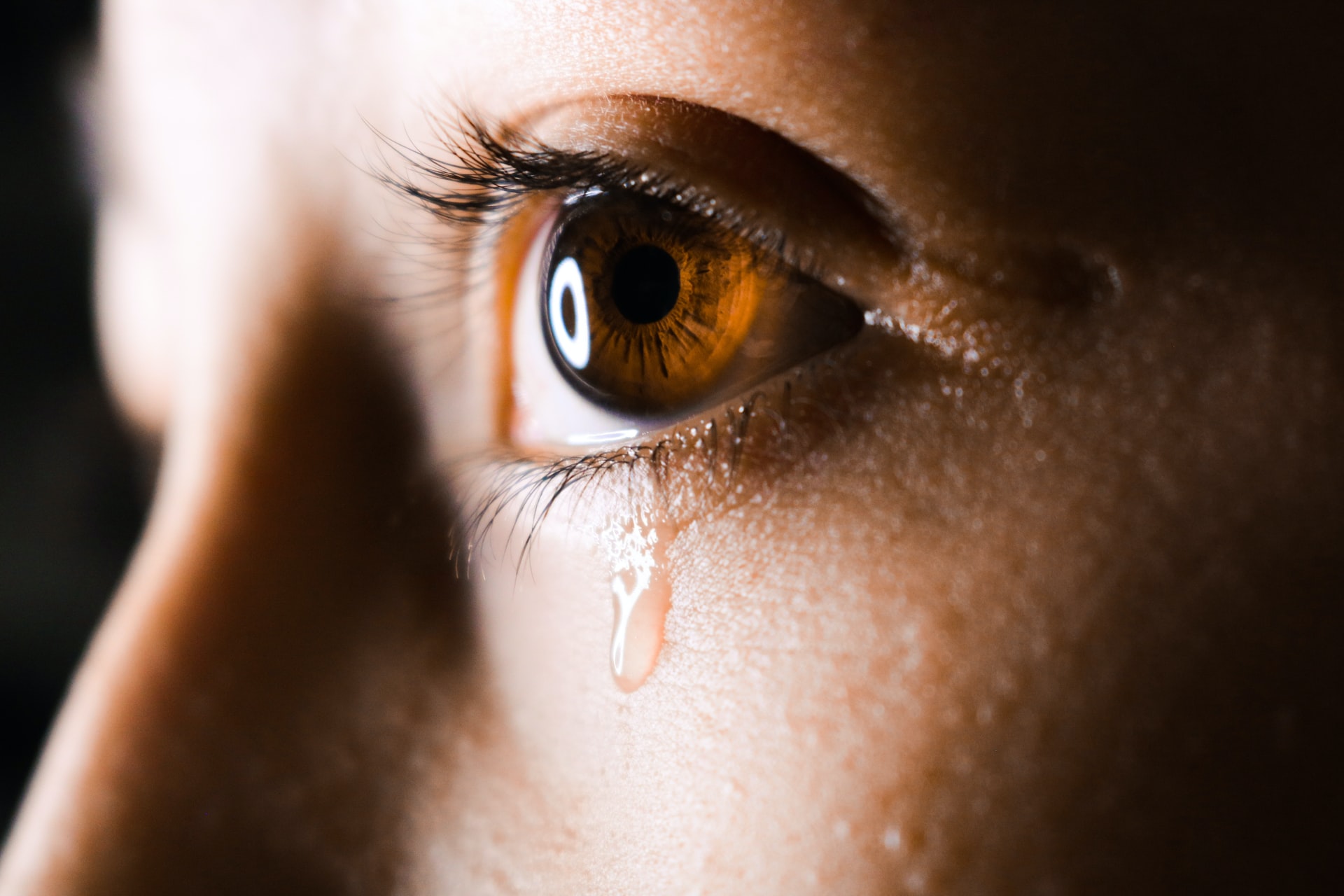 A closeup of a woman crying representing someone upset over a miscommunication in a divorce settlement