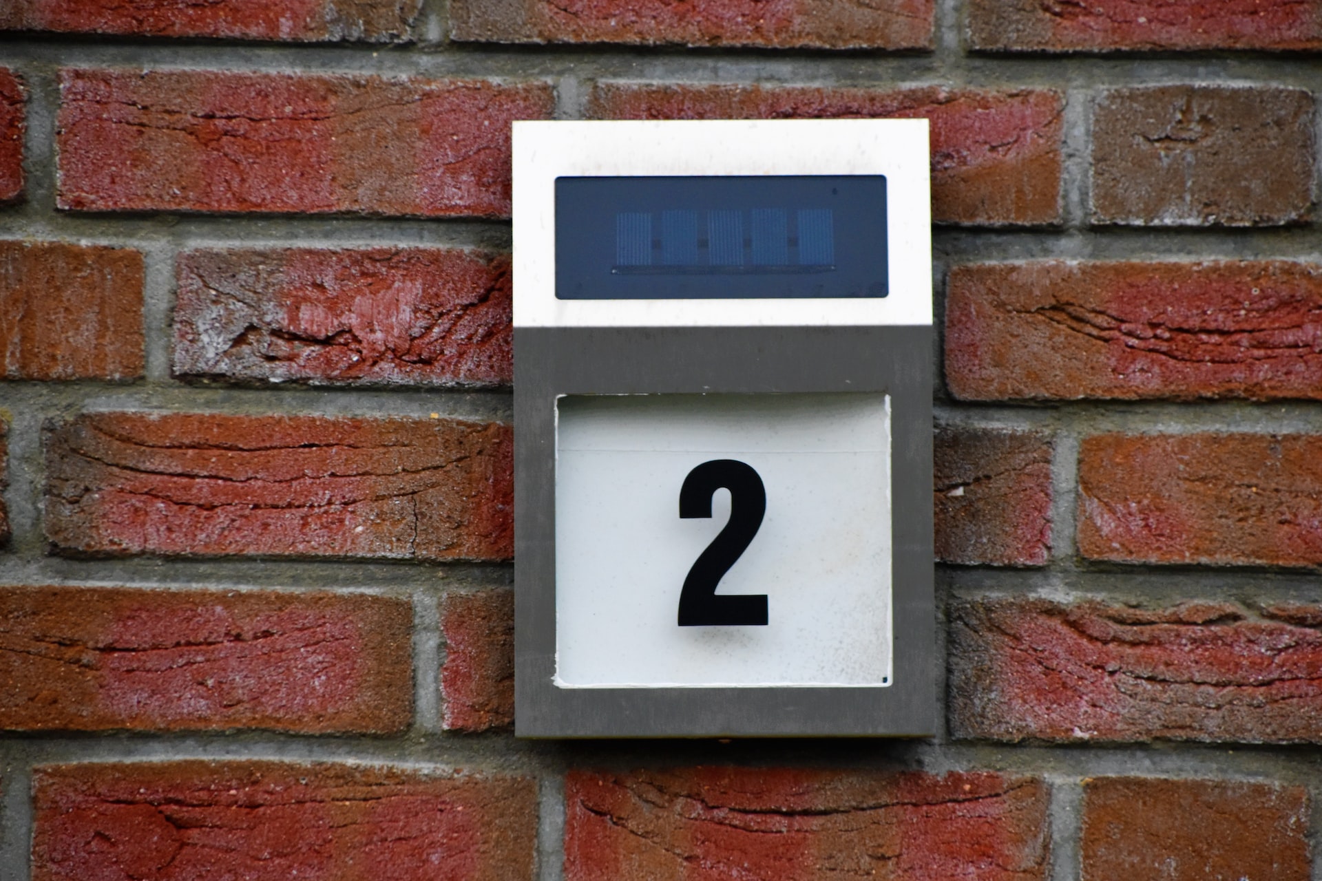 rectangular white and grey house number