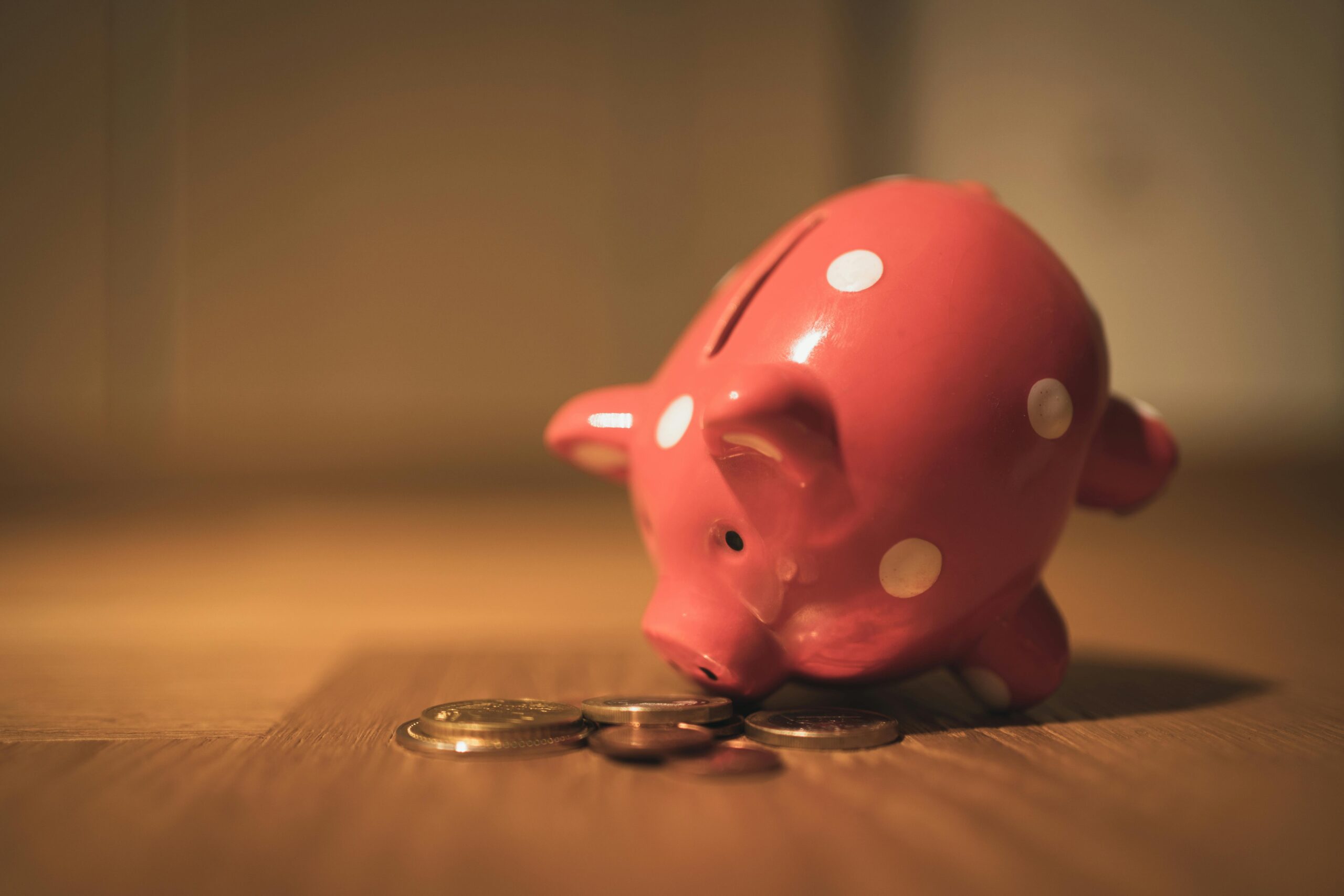 Piggy bank with coins spilling around representing a wealthy spouse's attempt to hide assets at time of separation