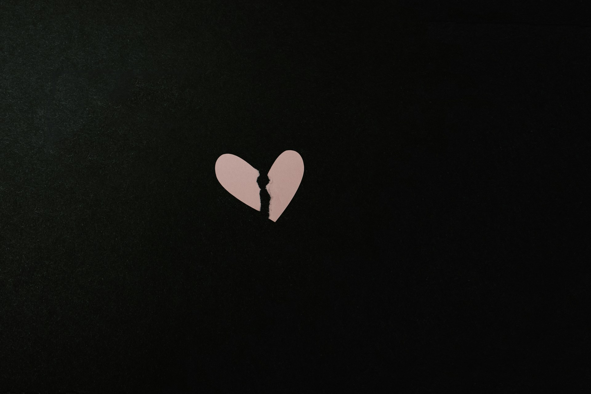 pink broken heart on black background