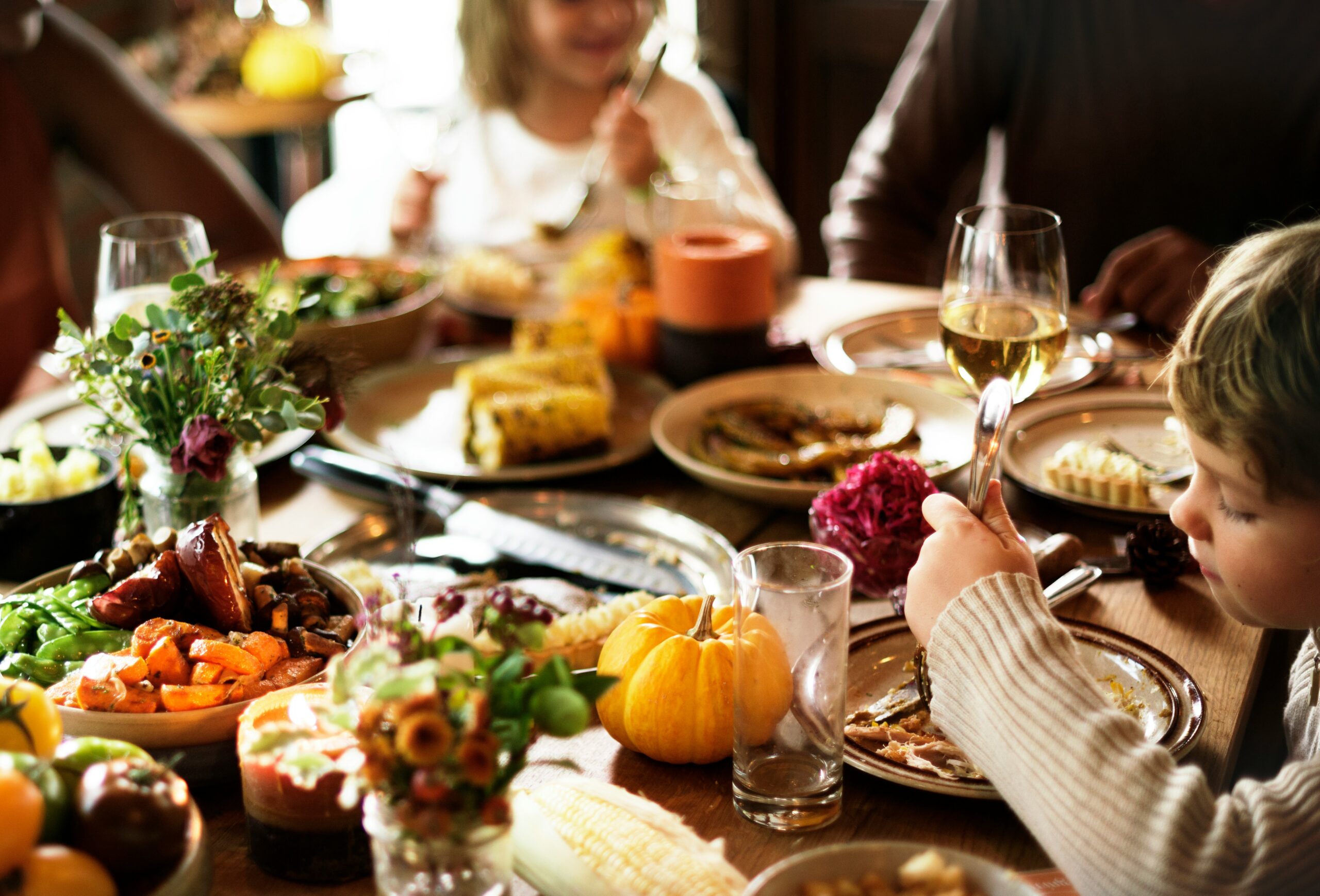 Two children enjoying Thanksgiving dinner at a festively set table, representing child access and custody arrangements during the holidays