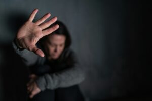 a woman sitting on the floor puttin her hand up in a stop motion