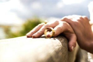 a woman holding a men's wedding band